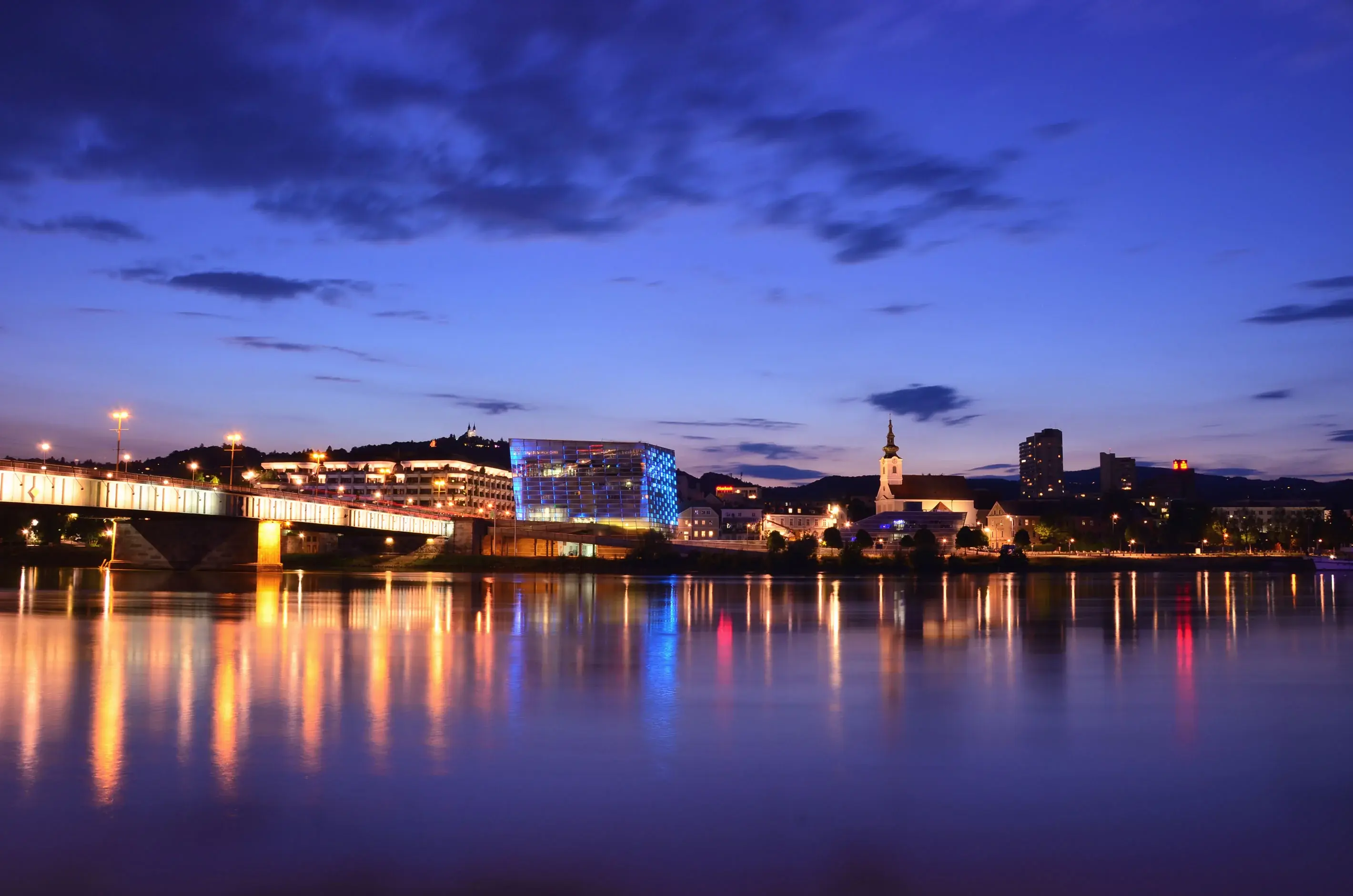 Linz Danube skyline at night with illuminated bridges and buildings
