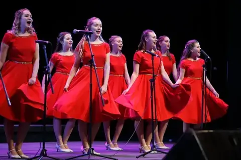 Choir in red costumes singing at full voice