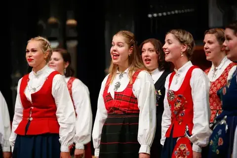 Choir in red and white folk costumes singing