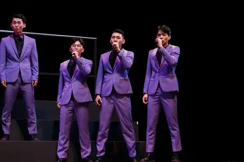 Pop choir performing under stage lights